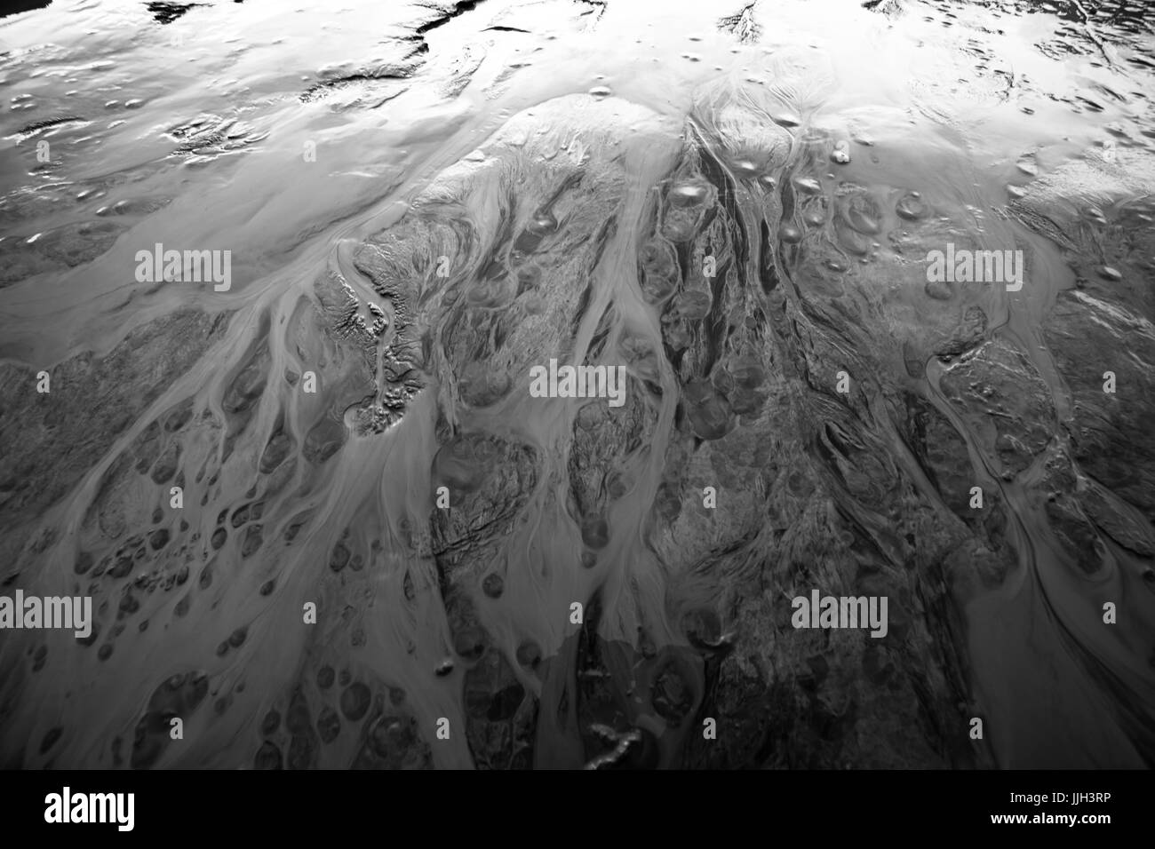 Melting glacial runoff forms braided rivers in silty earth. Stock Photo