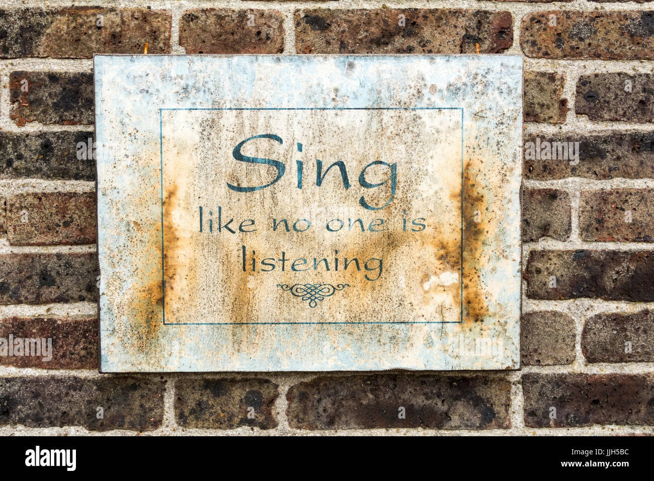 Sing like no one is listening plaque on a brick wall in Tilbury, Essex, England, UK Stock Photo