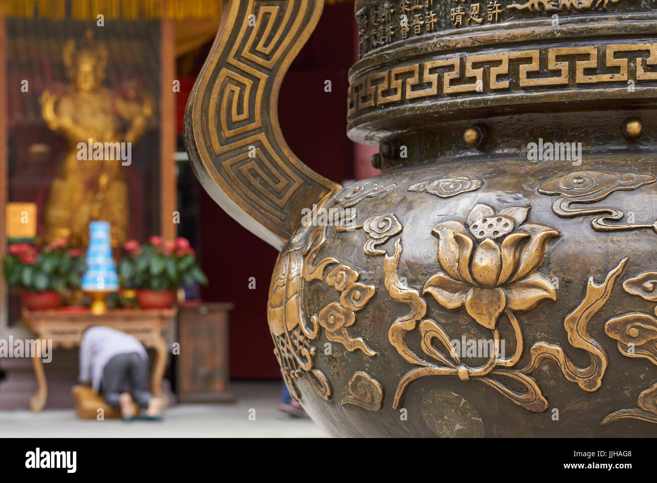 Incense burner and praying woman in Dafo Temple (also Big Buddha Temple), one of Guangzhou's most popular temples, China Stock Photo