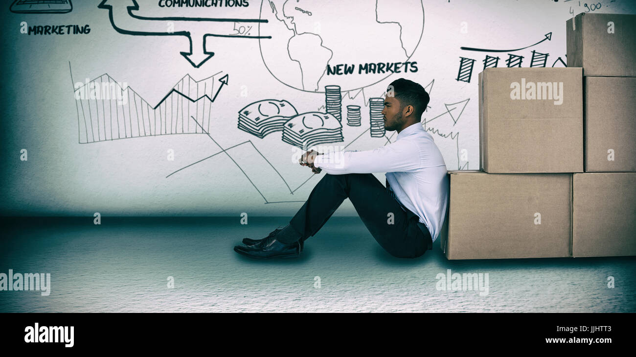 Businessman leaning on cardboard boxes against white background  against grey room Stock Photo