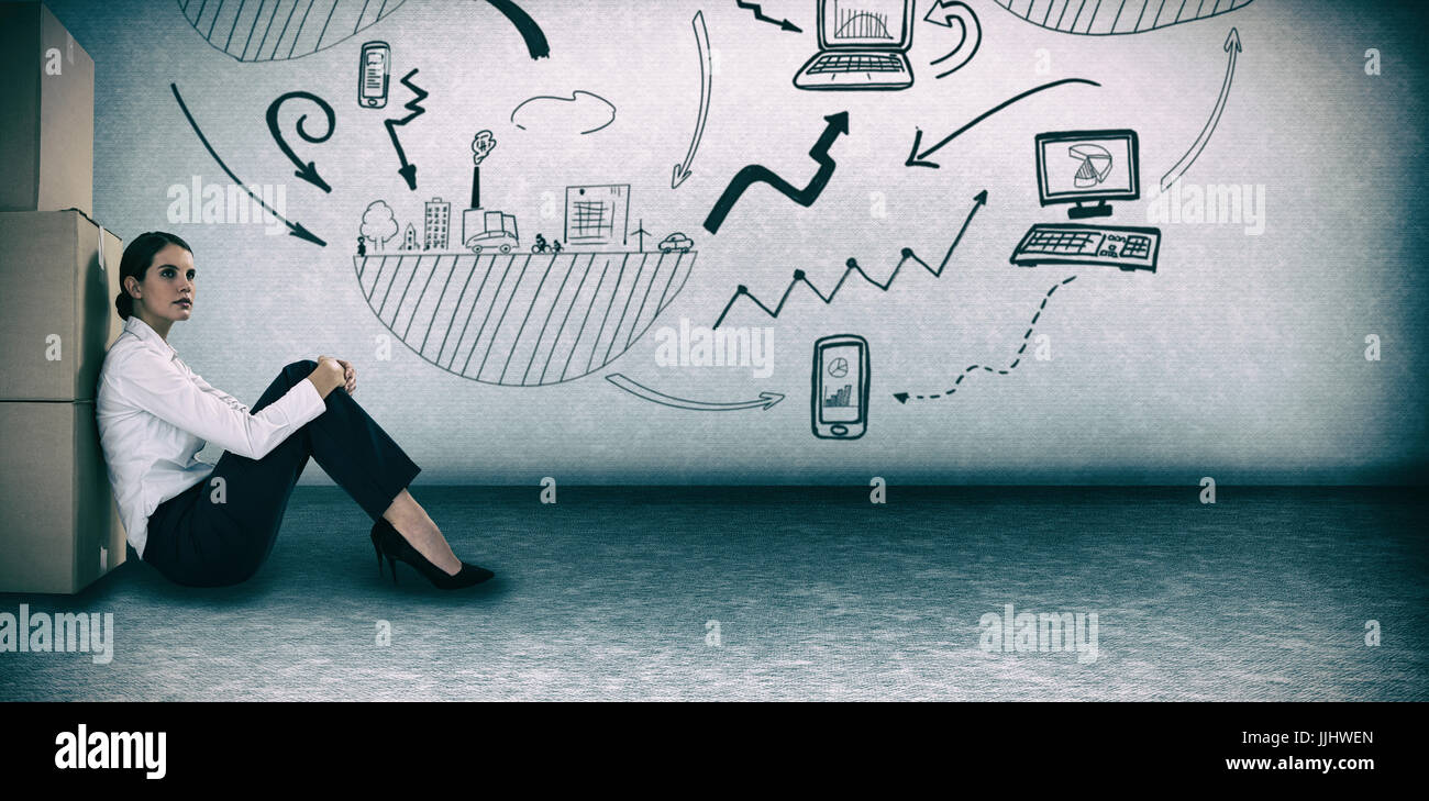 Businesswoman leaning on cardboard boxes against white background against grey room Stock Photo