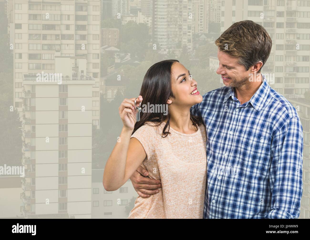 Couple Holding Keys with city high rises Stock Photo