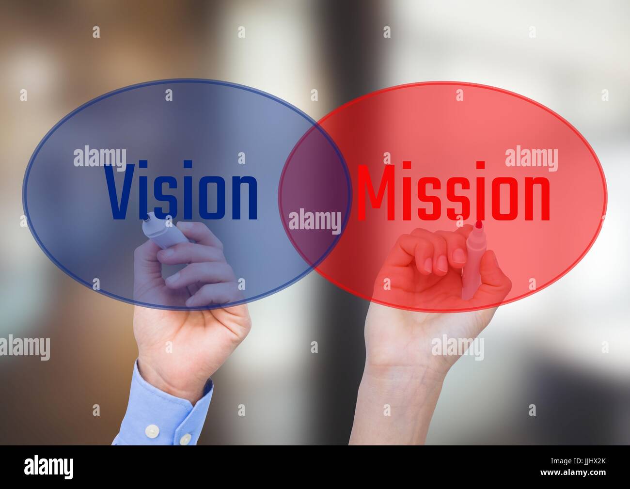 One hand writingVISION in blue circle with opacity and other hand writing MISSION in red circle with Stock Photo