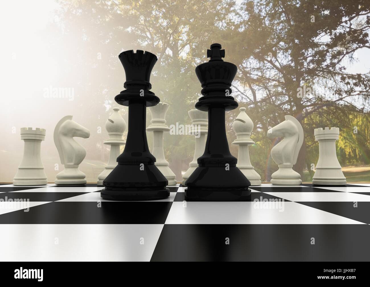 Chess pieces against blurry trees and flare Stock Photo