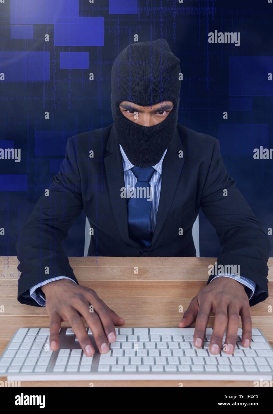 Hacker taping on keyboard on wood table Stock Photo