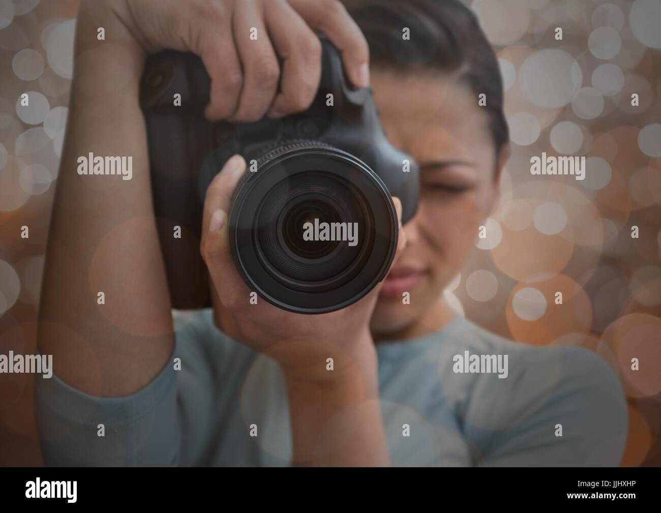 photographer foreground taking a photo with reflex. Blurred  brown lights background and overlap Stock Photo