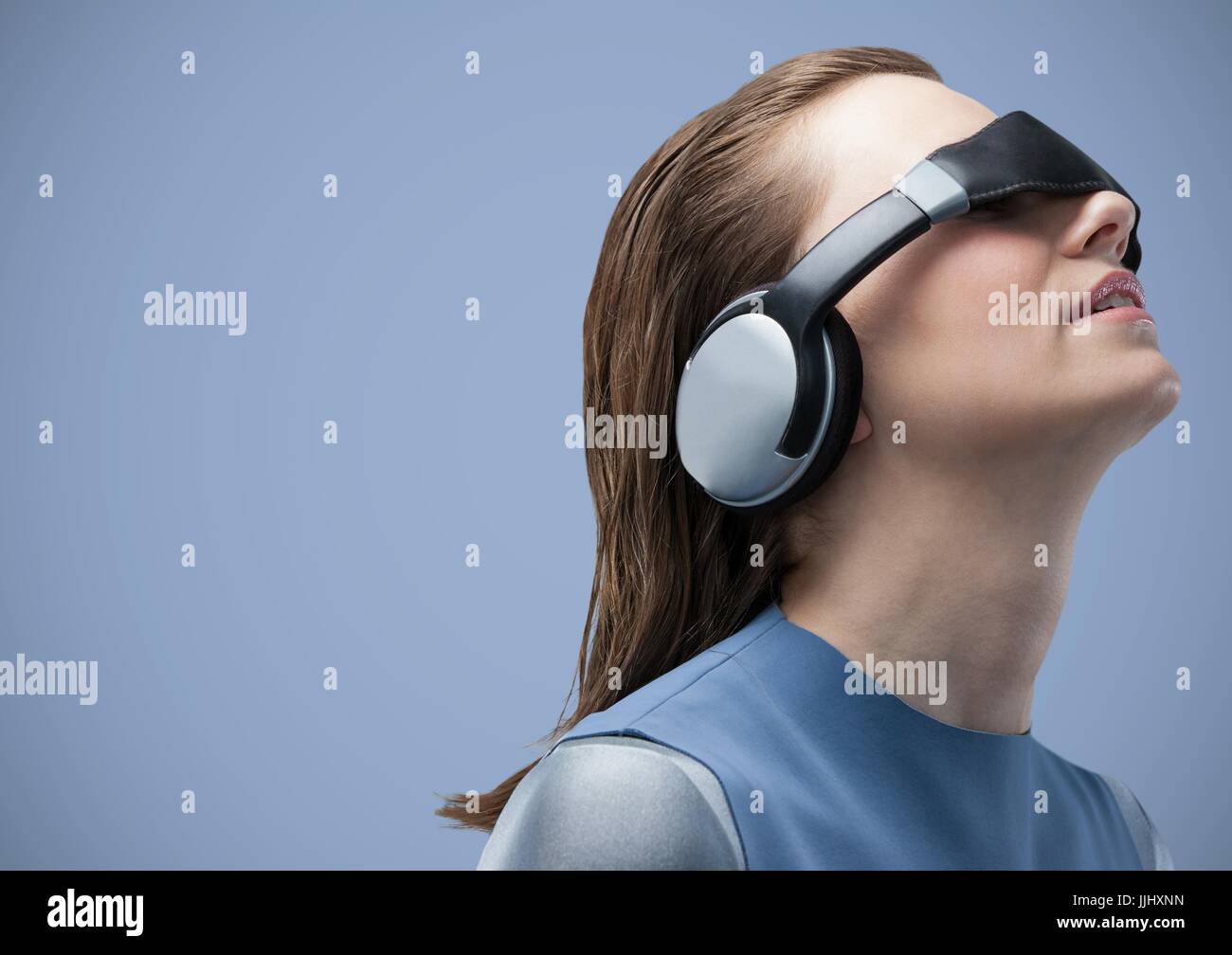 Woman in virtual reality headset against blue background Stock Photo Alamy