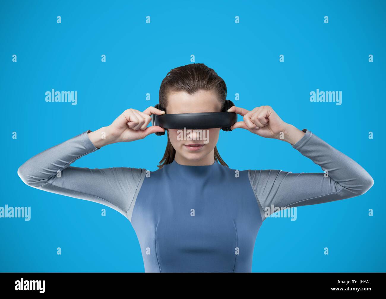 Woman in virtual reality headset against blue background Stock Photo ...