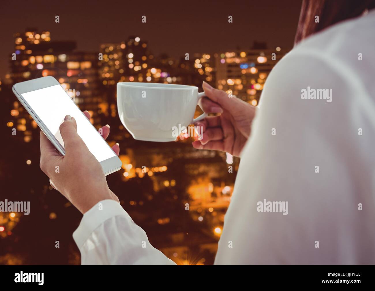 Part of a woman texting while having a coffee with buildings in background Stock Photo