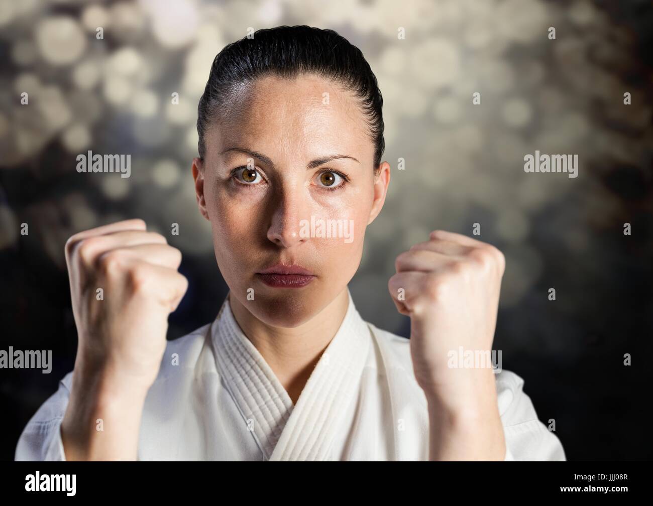Woman in karate suit against bokeh Stock Photo