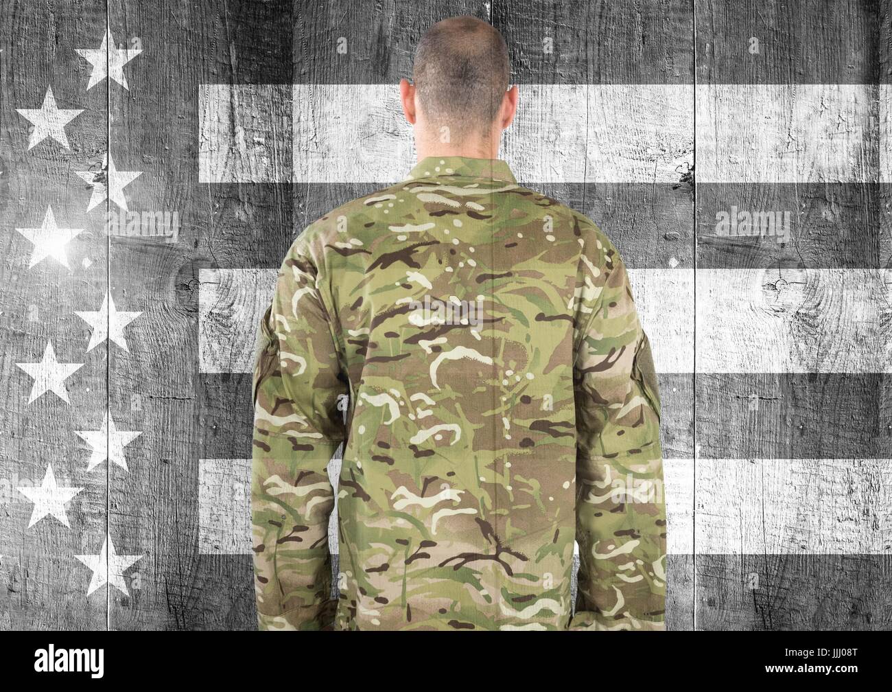 Rear view of military against black and white american flag Stock Photo