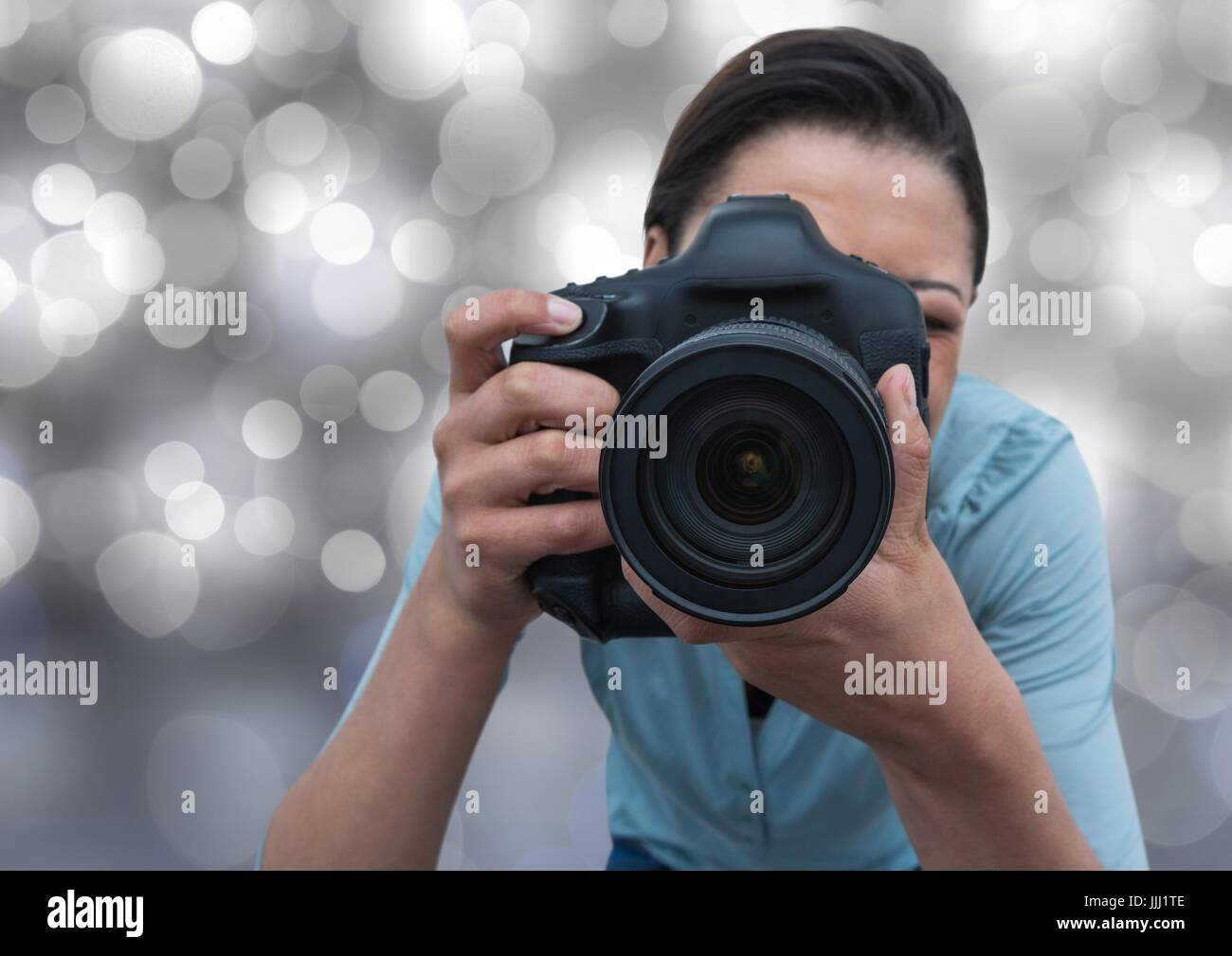 3d photographer taking a photo (foreground) with silver bokeh background Stock Photo