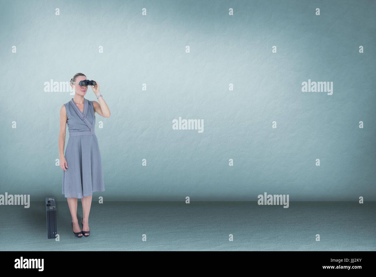 Woman looking through binoculars against blue background and copy space Stock Photo
