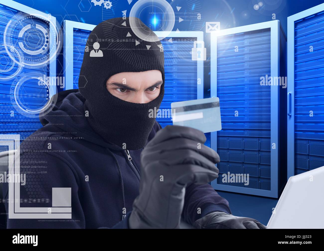 Hacker watching a credit card in a data center Stock Photo
