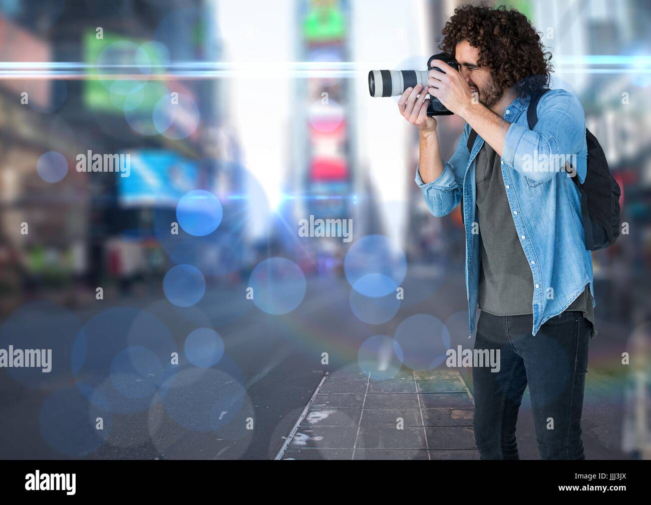 photographer taking a photo in the city. Blurred lights and flares everywhere. Stock Photo