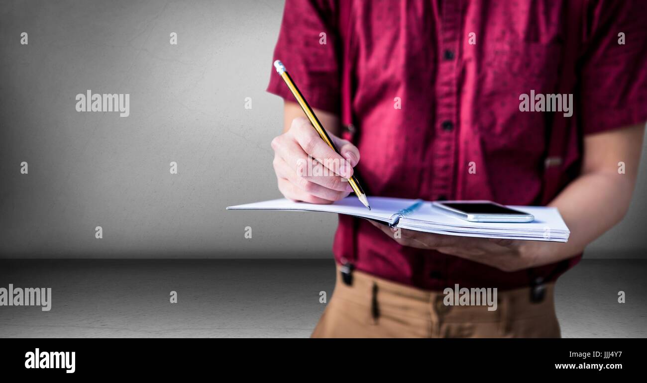 College student mid section with tablet against grey wall Stock Photo