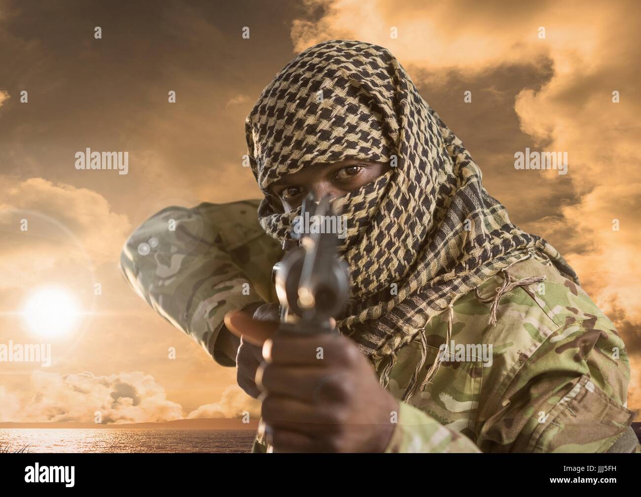 Military pointing with a gun against sunset Stock Photo