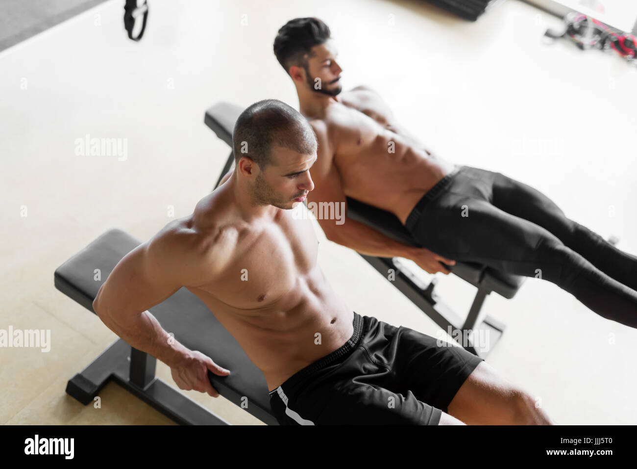 Strong men are doing abs crunches on bench Stock Photo Alamy