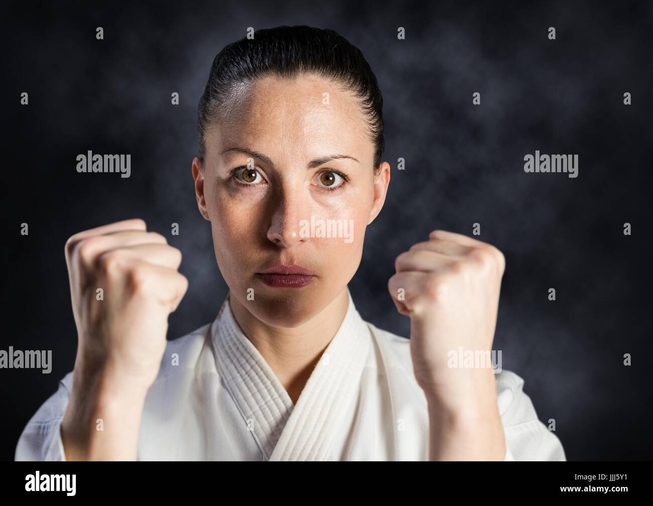 Woman in karate suit against mist Stock Photo