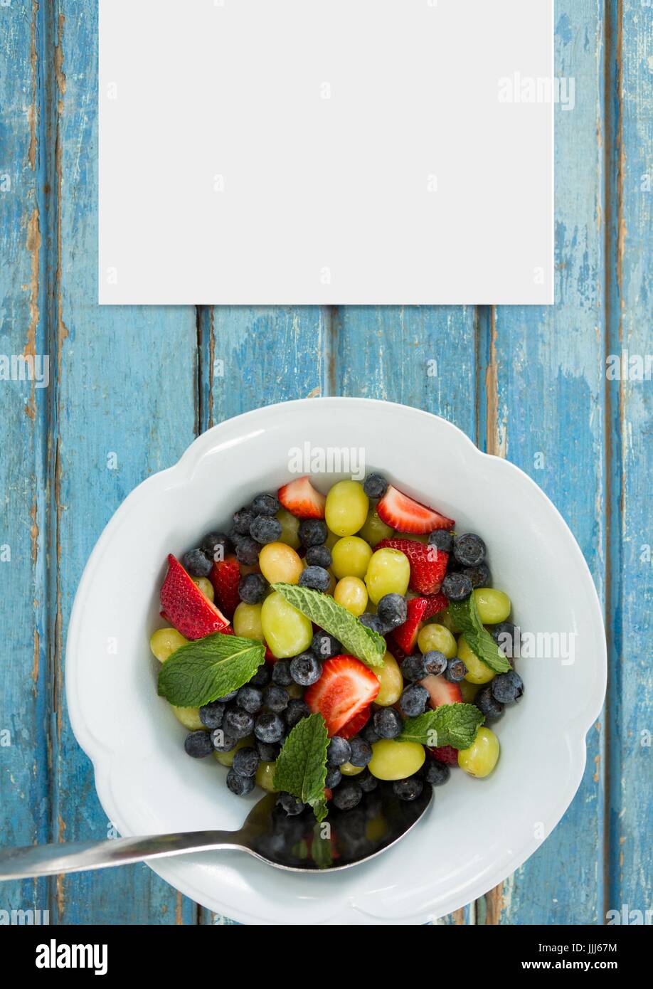 Blank card on blue wooden desk with food and copy space Stock Photo