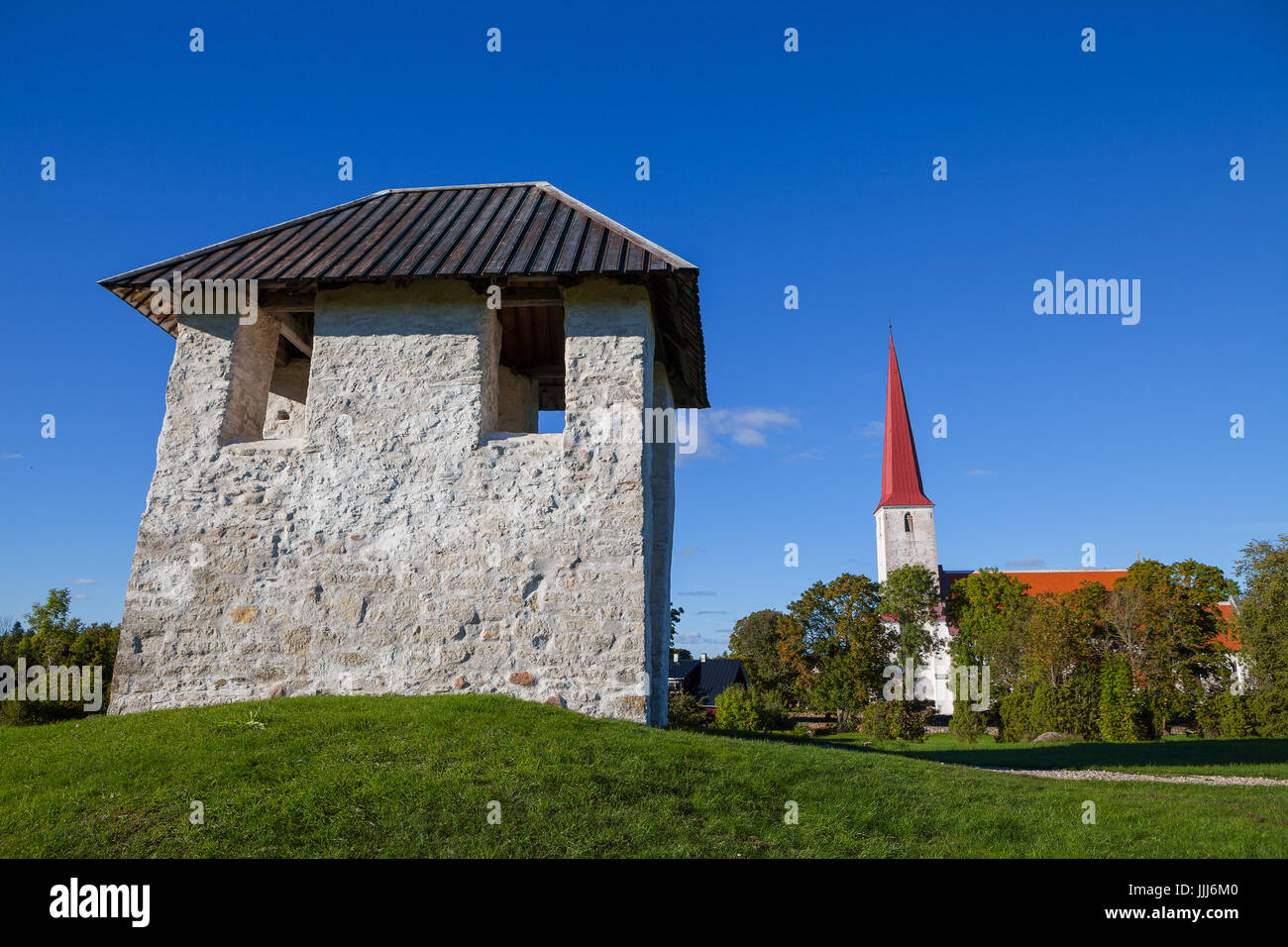Ancient Lutheran church and bellfry in Kihelkonna, Saaremaa, Estonia. Early autumn sunny day. Landscape view. Stock Photo