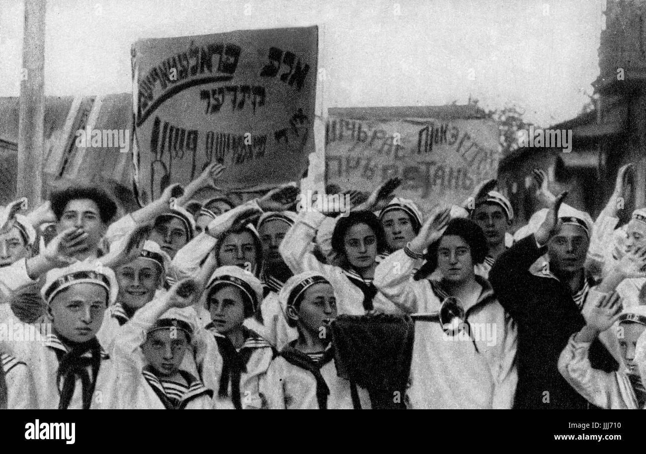 Jewish children in Soviet Union youth movement carrying Yiddish banners reading 'Alle Proletrarische Kinder' (We are all proletarian children ) in parade in Minsk, Belarus. Captions reads 'The pioneers salute the congress of the communist party of the USSR) Stock Photo