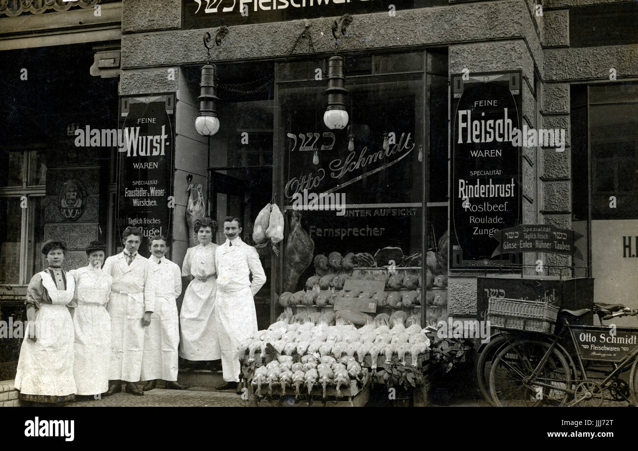 Kosher butcher's shop in pre-war Berlin. Otto Schmidt's shop is depicted with all of its employees standing outside and its wares on display.   Rows of chickens outside the shop. Photograph printed onto a postcard. Postal stamp from 21/11/1908. Stock Photo