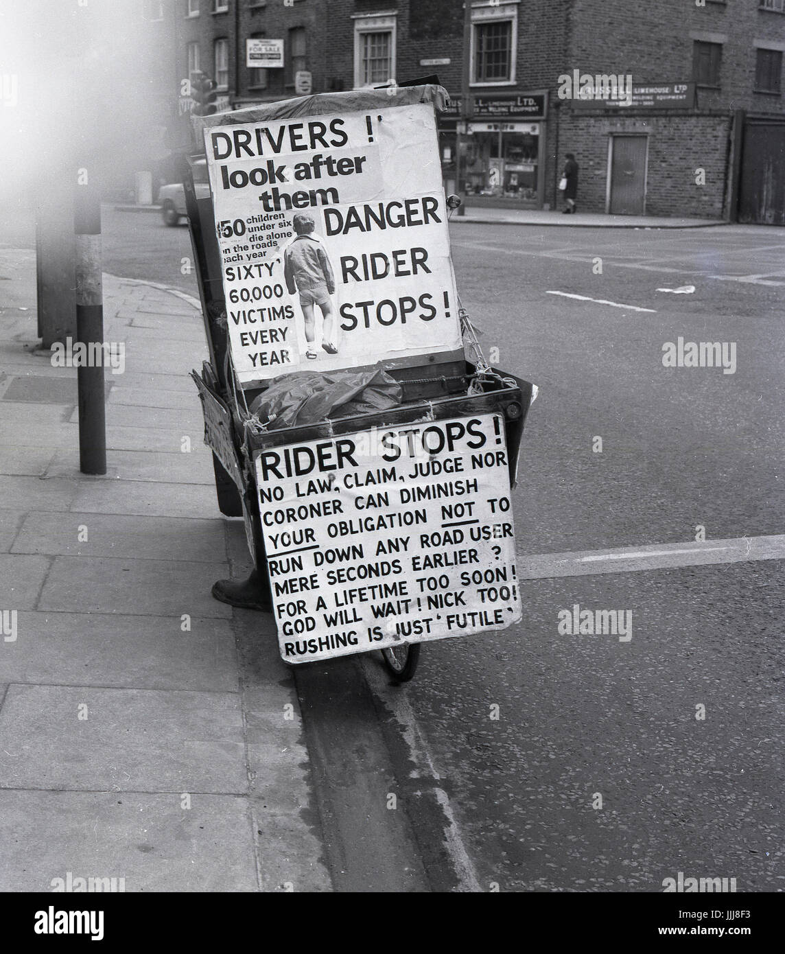 1971, Greenwich High Road, London, picture shows the eccentric Englishman and fervent poltical candidate Lt. Com William (Bill) Boaks on his 'campaign bus', a bicycle covered with placards and signs about road safety, a cause central to his beliefs.. Stock Photo