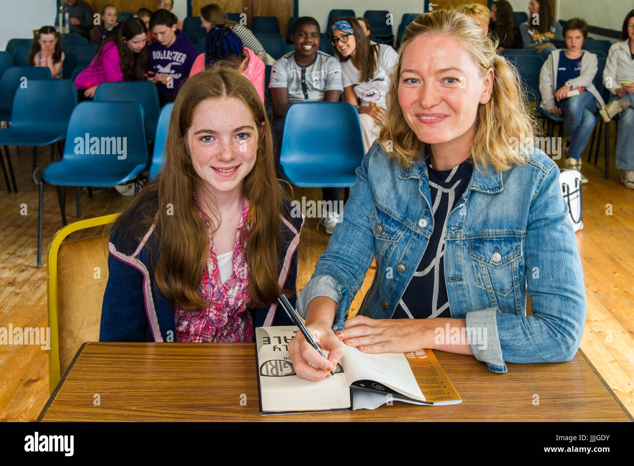 Bantry, West Cork, Ireland. 20th July, 2017.  Award-winning Geek Girl series children's book author, Holly Smale was in Bantry today to do a reading from her new book 'Forever Geek'.  As part of her visit, she met the winner of a book review competition, Caitlyn O'Donovan, aged 11 from Drimoleague, West Cork.  Holly is pictured signing Caitlyn's copy of the book. Credit: Andy Gibson/Alamy Live News. Stock Photo
