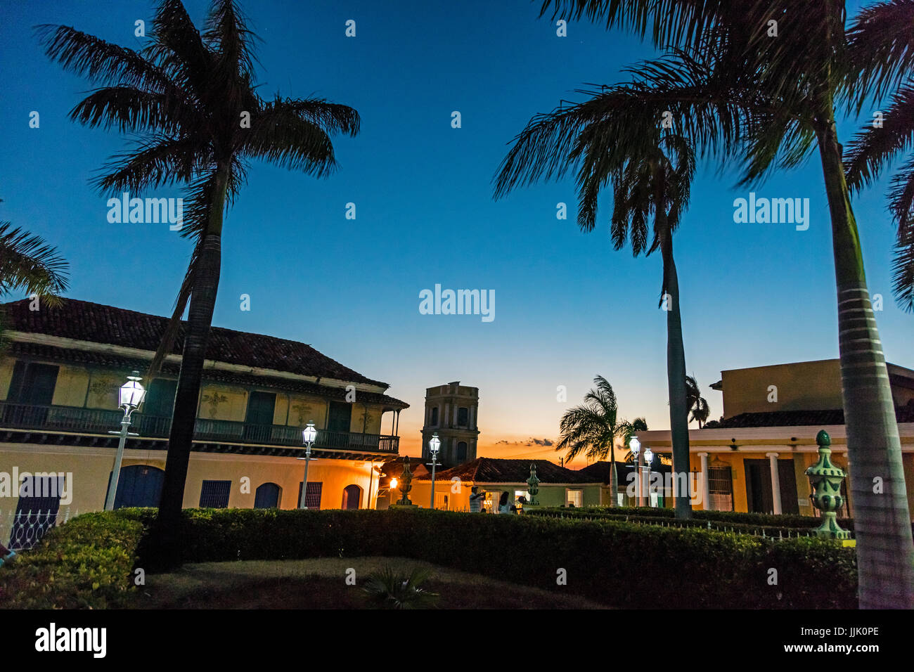 Palm trees and historic buildings on the PLAZA MAYOR at dusk - TRINIDAD, CUBA Stock Photo