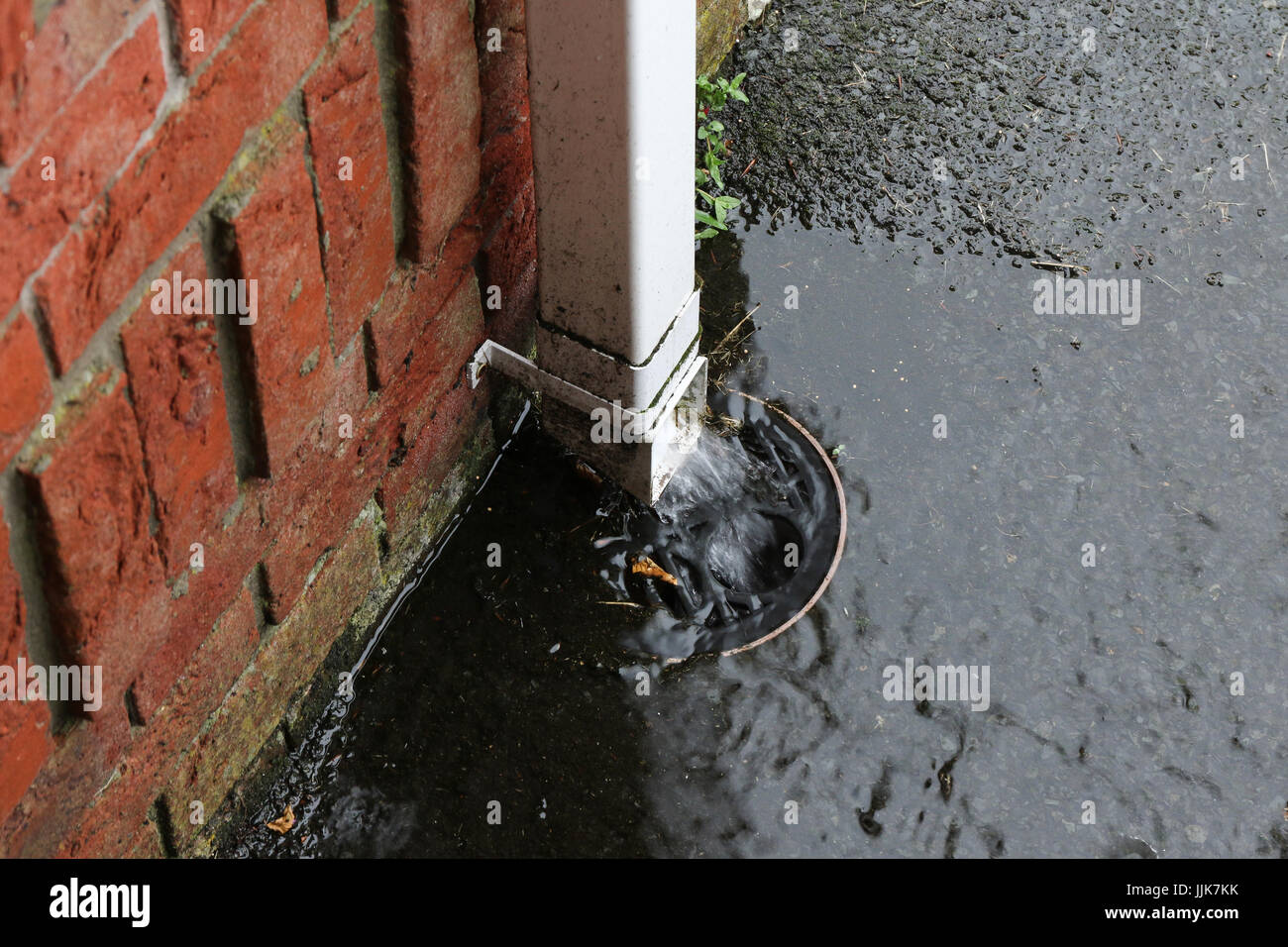 Water pouring down plastic downspout following heavy rain Stock Photo