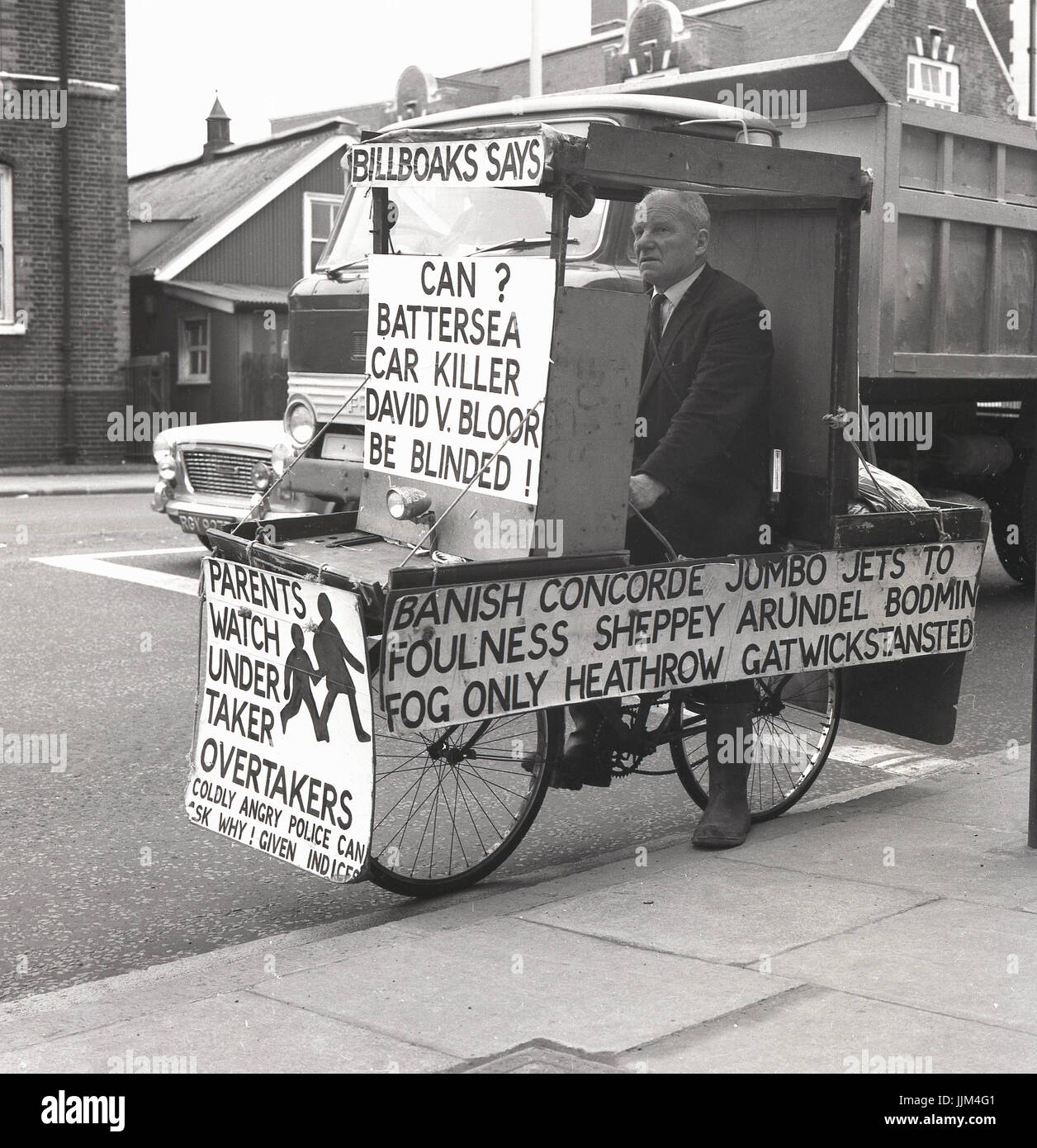 1971, Greenwich High Road, London, picture shows the eccentric Englishman and fervent poltical candidate Lt. Com William (Bill) Boaks on his 'campaign bus', a bicycle covered with placards and signs about road safety, a cause central to his beliefs.. Stock Photo