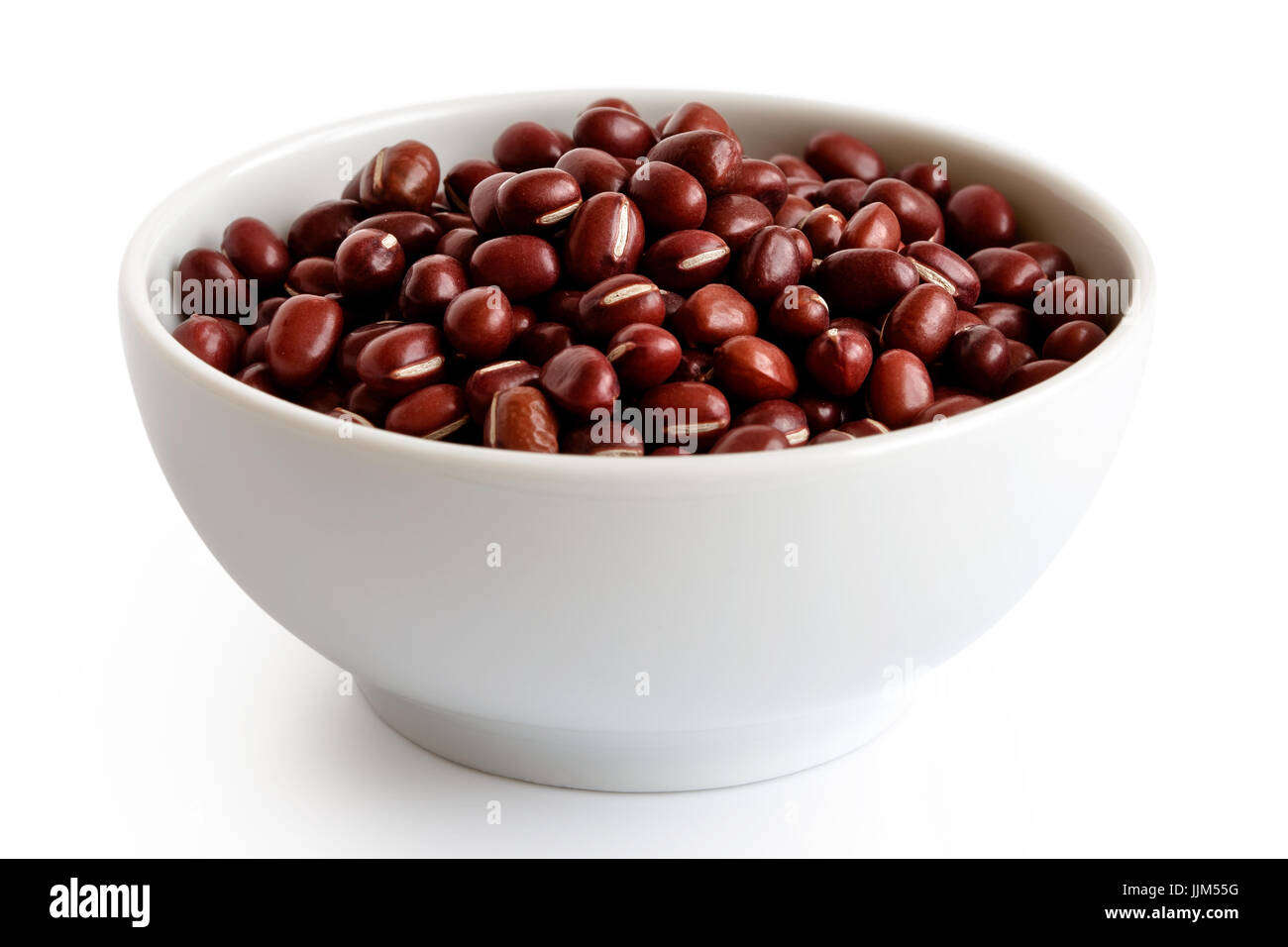 Dry adzuki beans  in white ceramic bowl isolated on white. Stock Photo