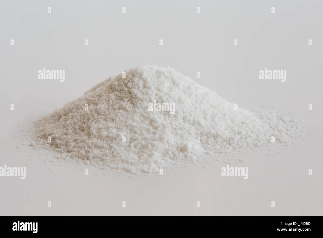 Heap of white rice flour isolated on white. Stock Photo