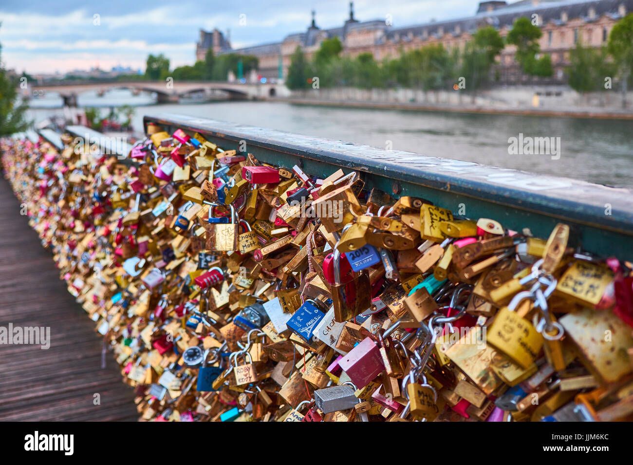 PARIS, FRANCE - JULY 26, 2015: Love locks on a fence on the access ramp to the Pont des Arts over the River Seine in Paris which is covered with thous Stock Photo