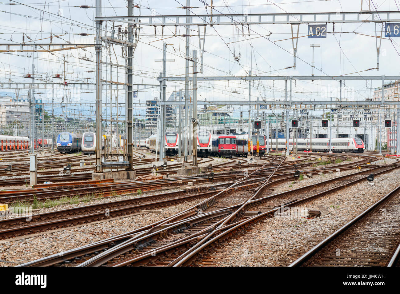 Rail yard with trains and overhead lines of Genève-Cornavin railway station under a cloudy sky. Geneva, Switzerland. Stock Photo