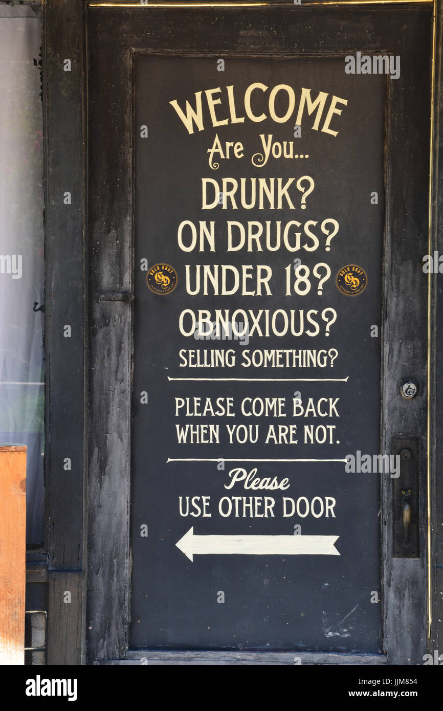 Sign on the door of a neighborhood tattoo shop. Stock Photo