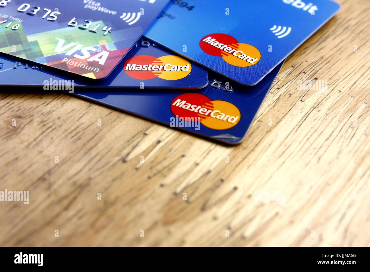 ANTIPOLO CITY, PHILIPPINES - JULY 17, 2017: A bunch of Mastercard and Visa credit cards spread on a wooden table Stock Photo
