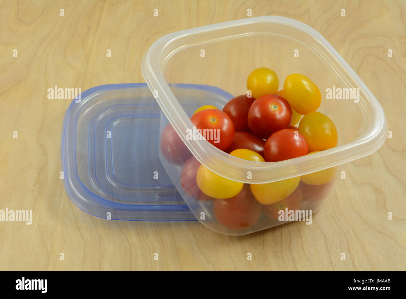 Red and yellow variety cherry tomatoes in refrigerator plastic storage container Stock Photo Alamy