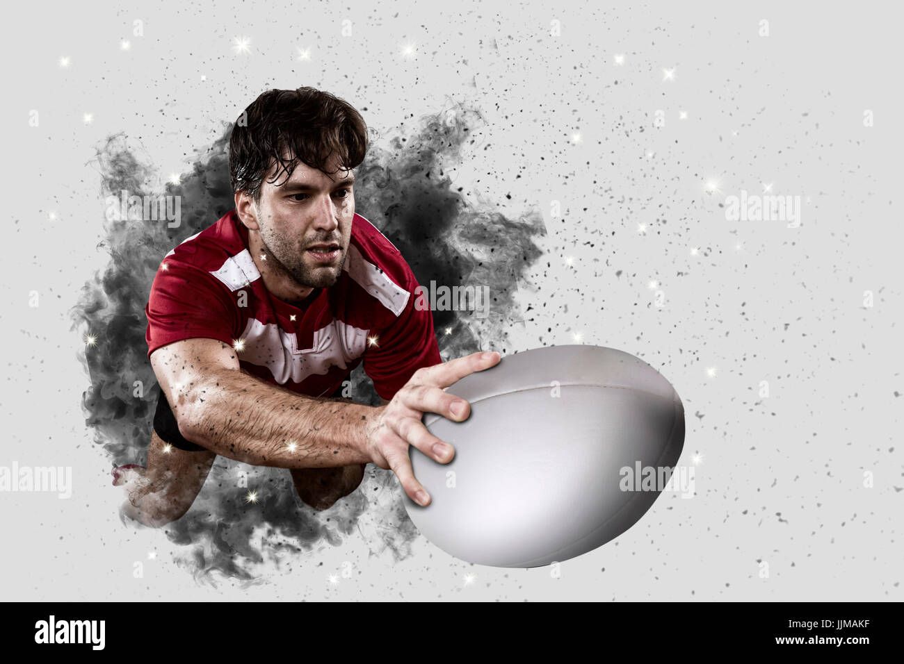 Rugby Player with a red uniform coming out of a blast of smoke . Stock Photo