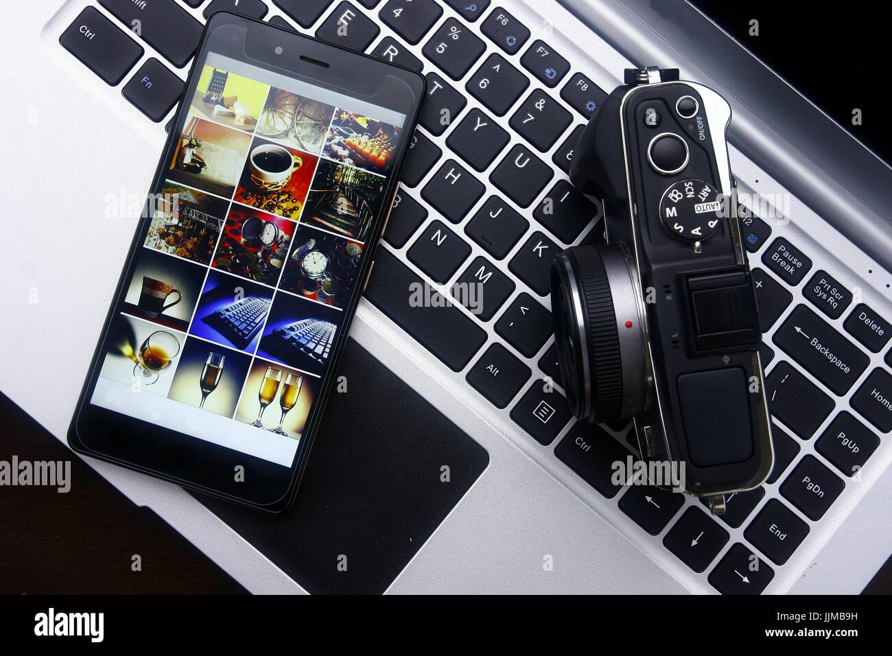 Photo of a smartphone,digital mirrorless camera and laptop computer