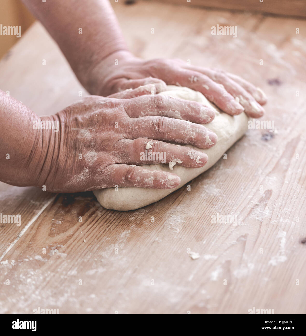Grand mother makes traditional dumplings. Close up on working hands. Saturated faded tones Stock Photo