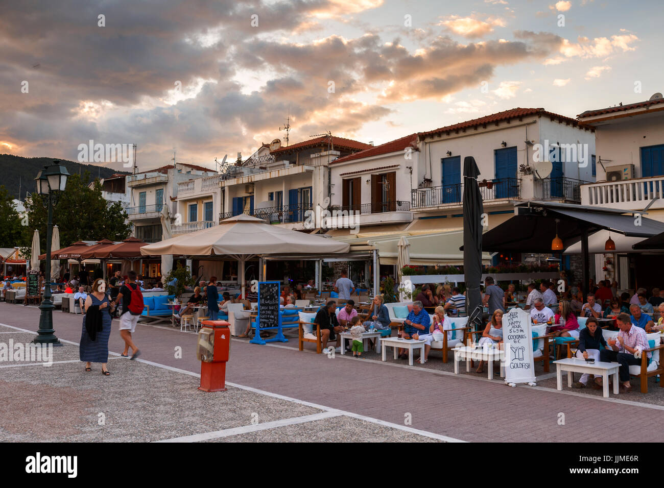 Evening view of coffee shops in the old harbour of Skiathos town ...