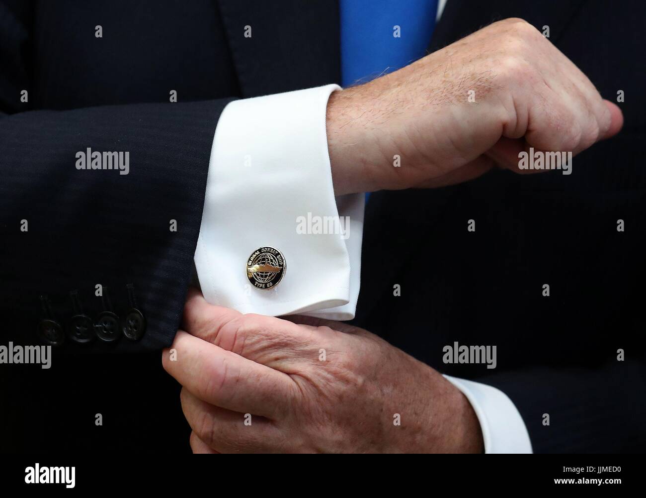 Defence Secretary Sir Michael Fallon shows off his cufflinks after cutting steel on the first Type 26 frigate at BAE System's Govan Shipyard near Glasgow. Stock Photo