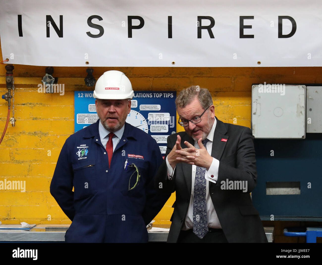Secretary of State for Scotland Sir David Mundell (r) chats with BAE Systems worker James McDowall as the cutting of steel on the first Type 26 frigate began at BAE System's Govan Shipyard near Glasgow. Stock Photo