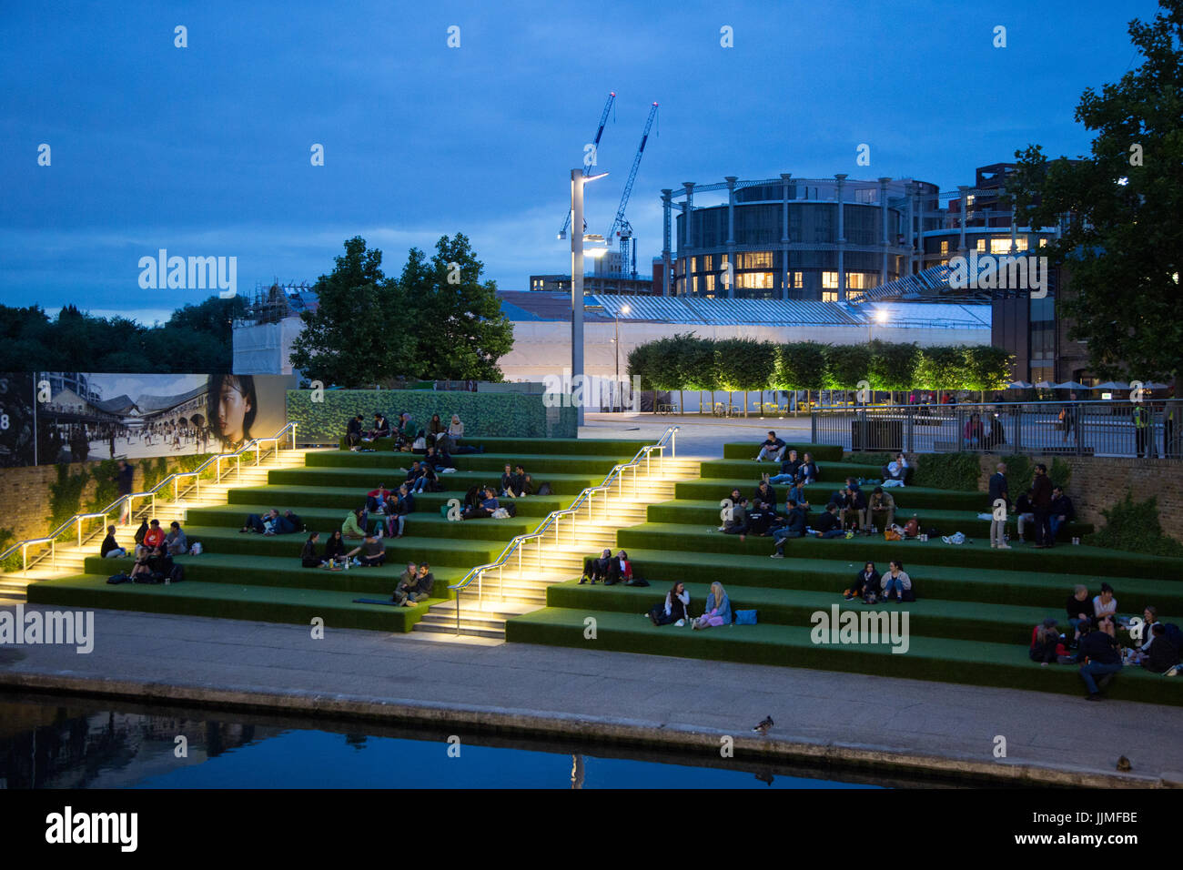 Londoners enjoying a warm summer night by the Grand Union Canal in Kings Cross, outside Granary Square Stock Photo