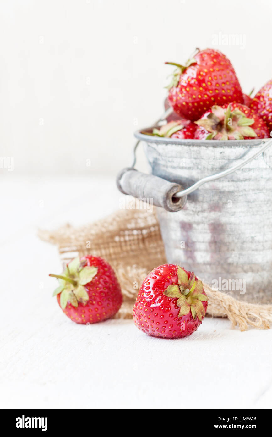 Fresh juicy strawberries in an old iron bucket on a white background ...