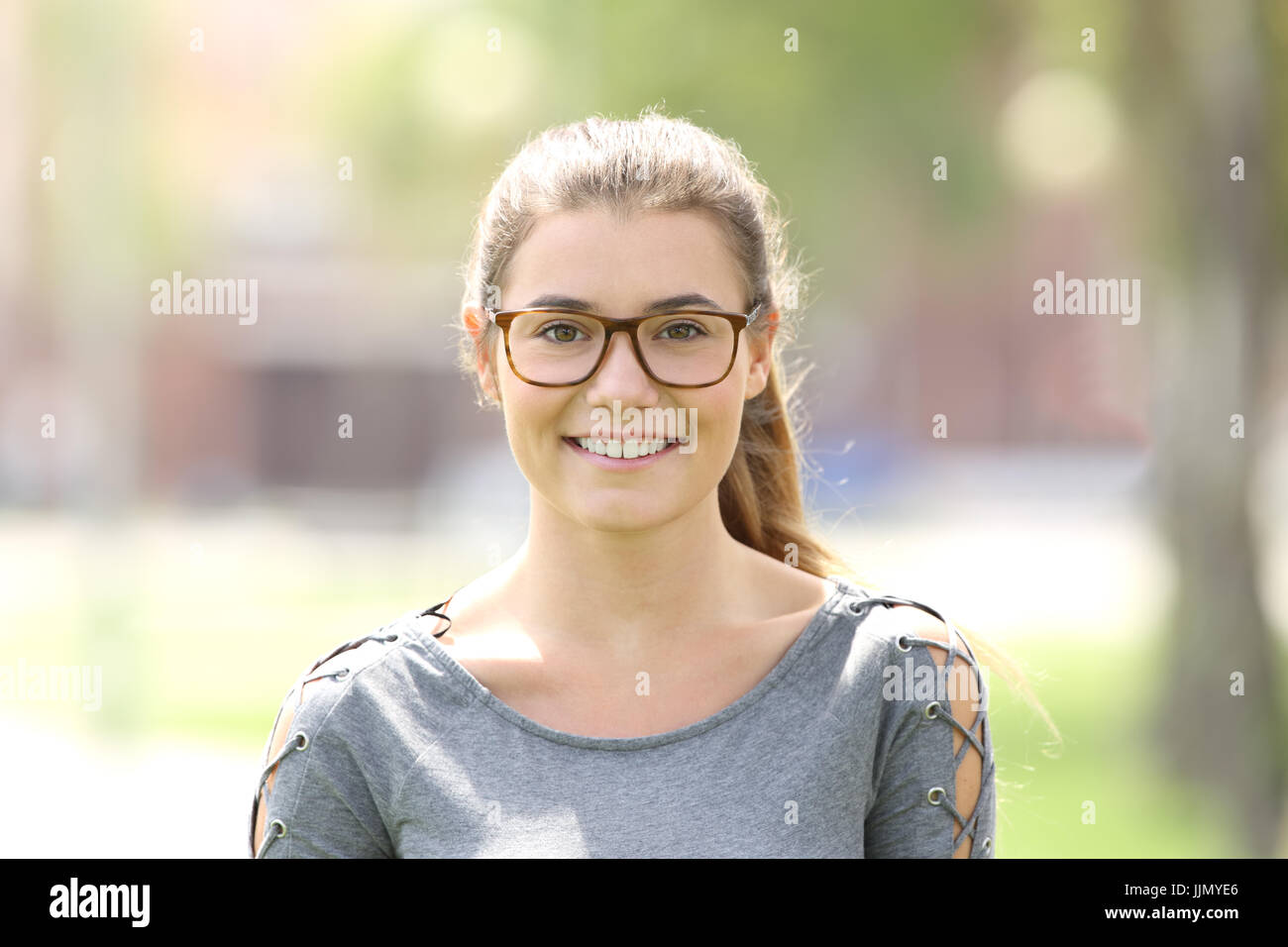 Portrait Of A Girl Wearing Eyeglasses Looking At You Outdoors In A Park