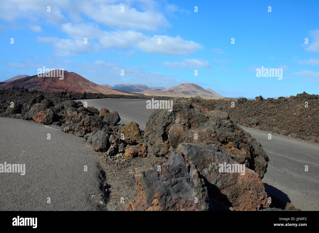 A road with a view to volcanic mountains in Timanfaya National Park on Lanzarote, the Canary Islands, Spain Stock Photo