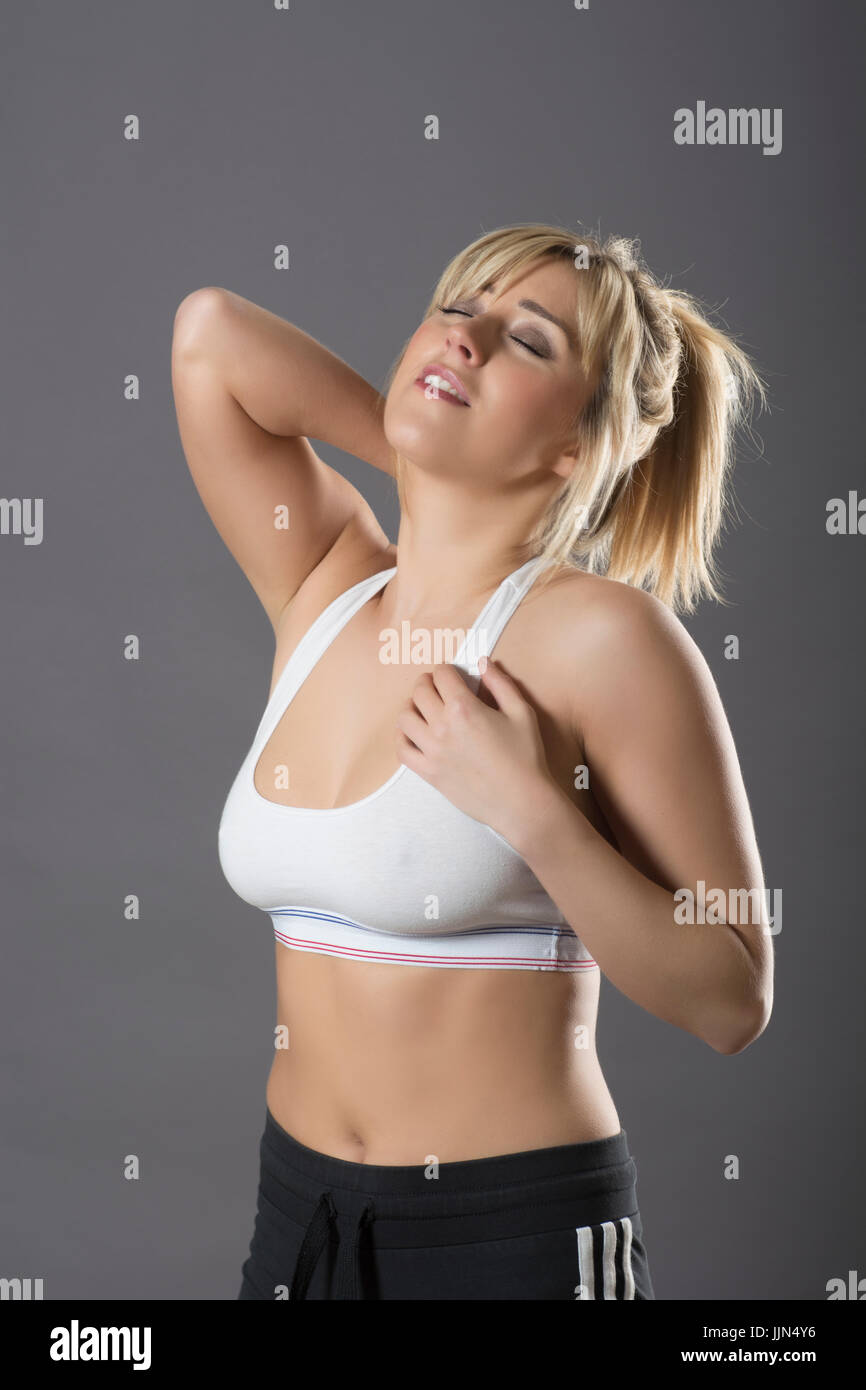 Woman wearing sports bra with back pain tired from exercise Stock Photo